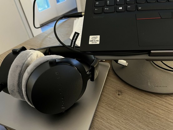 A photo of a beyerdynamic headphone on a desk connected to a ThinkPad X1 which is also partially visible.